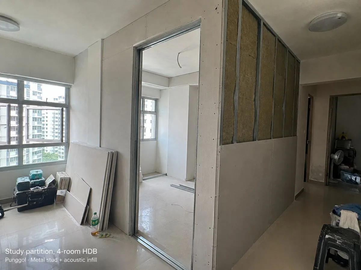 Partition wall framing mid-installation, acoustic infill visible