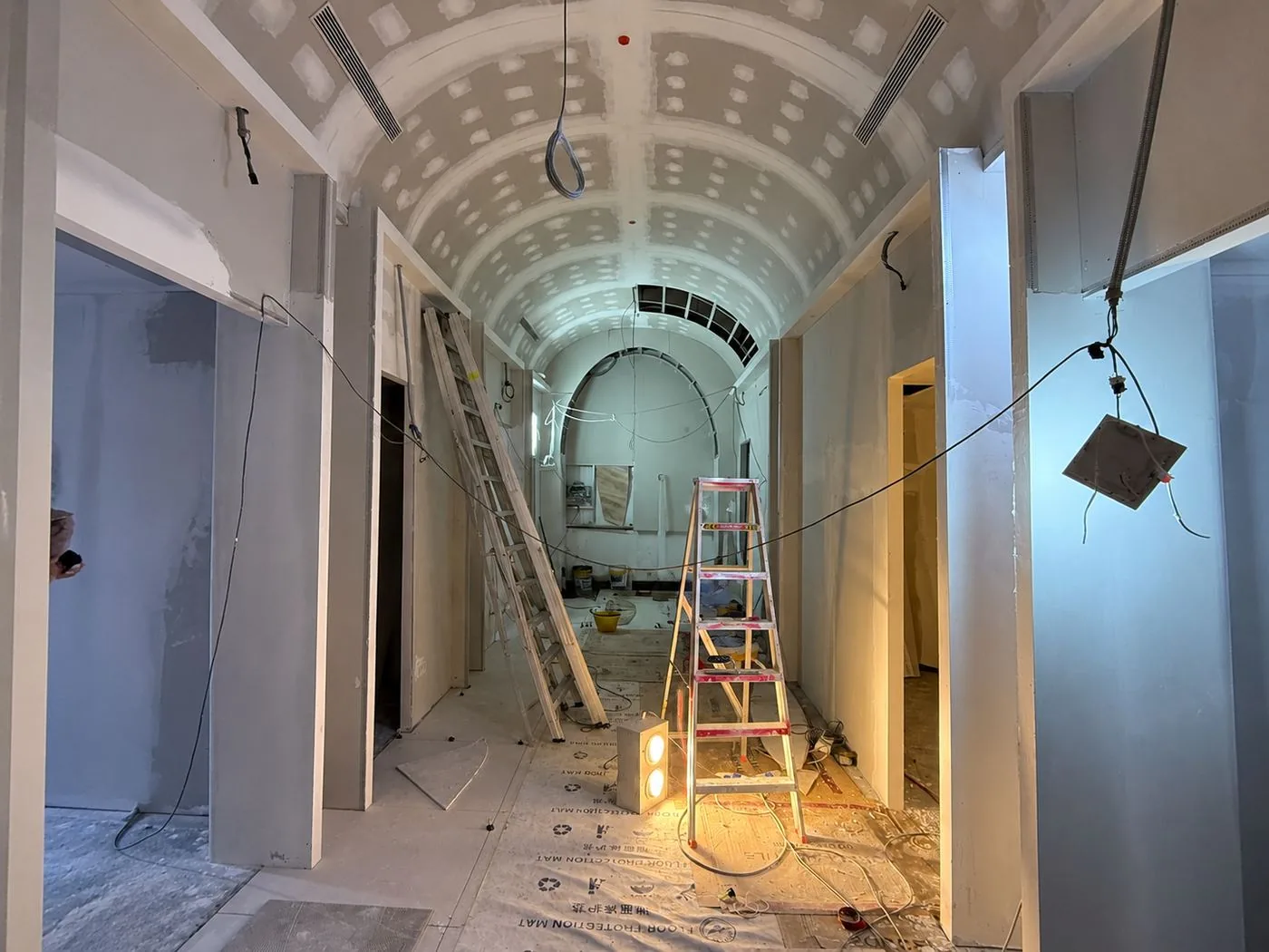 Before: the same corridor as a bare shell, ceiling arches unfinished
